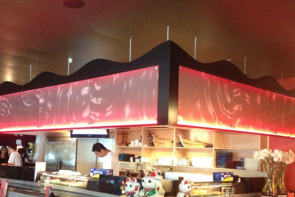 Illuminated Panels with Ripple Graphic Above Sushi Bar